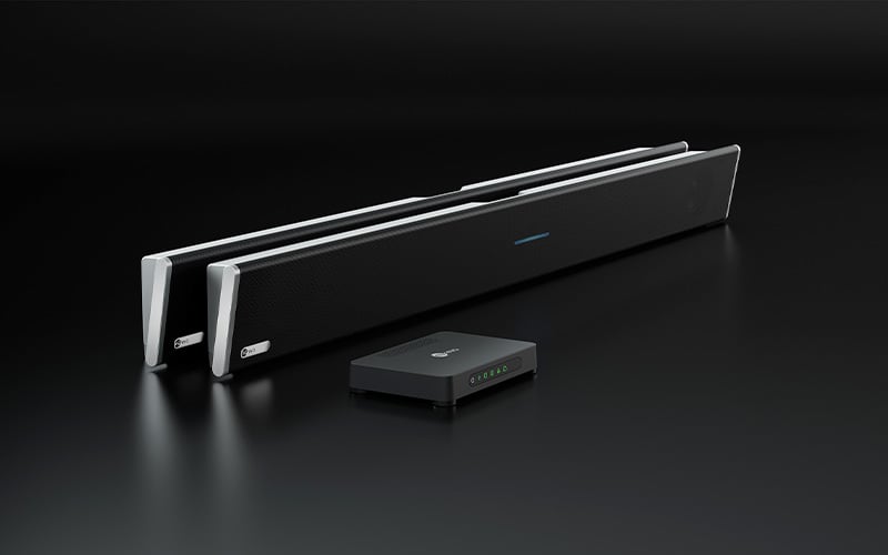 A Nureva HDL410 audio conferencing system on a dark background, comprising two black horizontal microphone and speaker bars and a rectangular compact connect module.