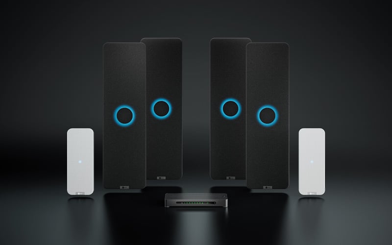 A Nureva HDX series system on a dark background, with four black vertical audio bars, two white vertical microphone pods and a rectangular aluminum system hub, ideal for extra-large meeting rooms and classrooms.