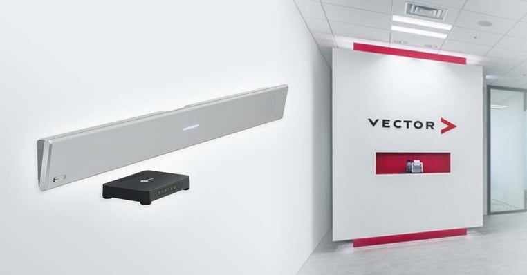 A white Nureva HDL310 microphone and speaker bar shown on a white wall beside its black connect module. In the background, a modern office entrance displays the Vector Japan logo on a white and red feature wall.