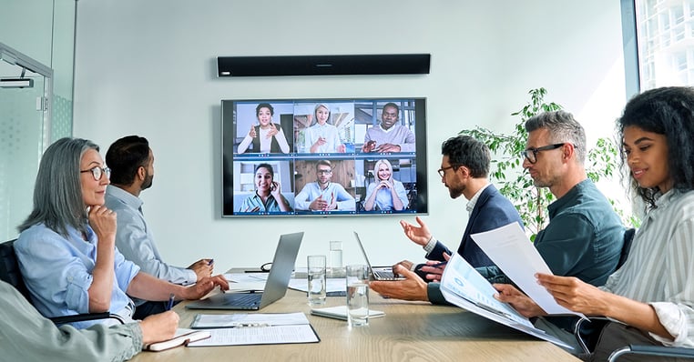 People in the office and remote gather for a hybrid meeting