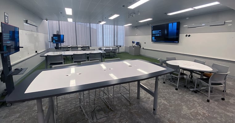 A collaborative higher ed classroom at Monash University with several tables, displays and a Nureva audio system.