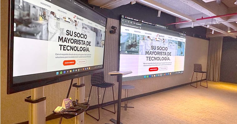 The front of an auditorium equipped with two large displays.