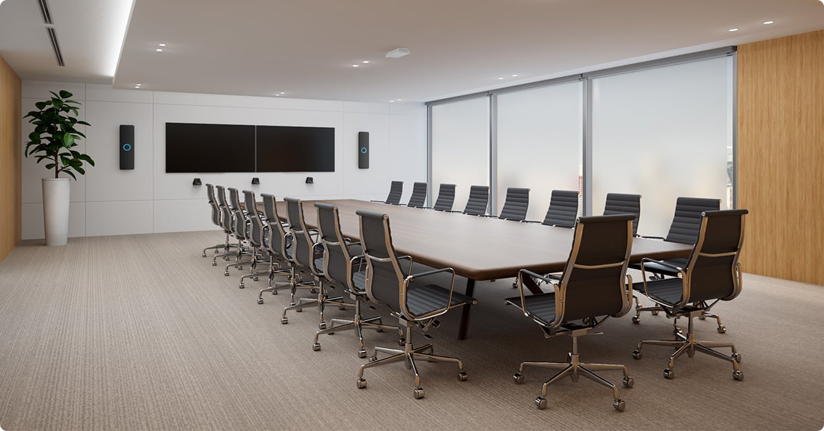 Large modern meeting room with a long conference table, multiple executive chairs, dual displays and Nureva HDX in 2-bar, 1-pod setup for full-room microphone coverage and premium audio conferencing.