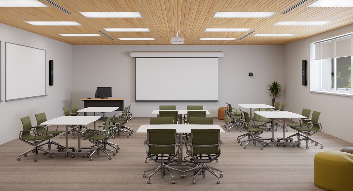 Modern multipurpose classroom with flexible seating, interactive whiteboards, and Nureva HDX in 4-bar setup for full-room mic coverage.