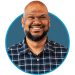 Male in a checkered shirt smiling inside a blue circle.