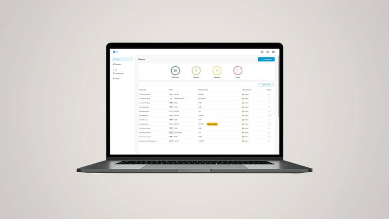 Nureva Console dashboard on a laptop listing rooms and device status.
