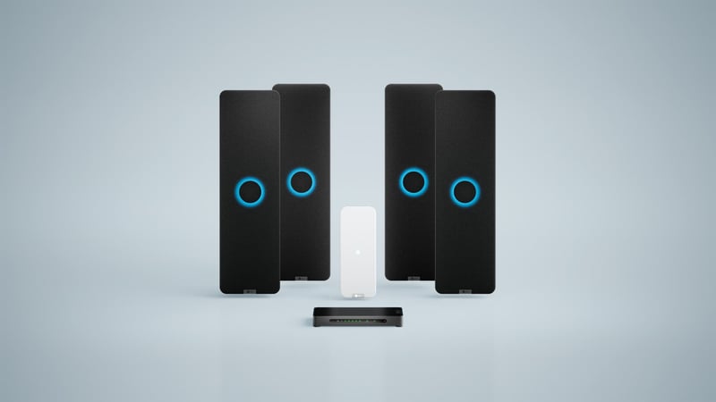 Nureva HDX system with four black audio bars, white microphone pod and a system hub for large meeting spaces.