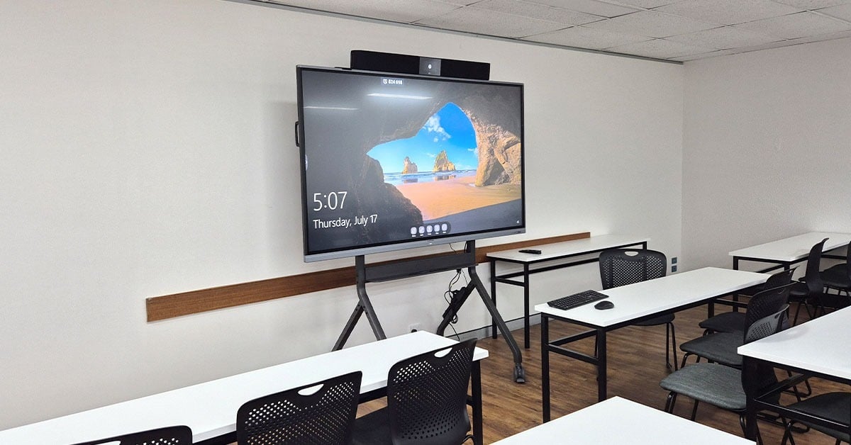 Canterbury Institute of Management classroom with a Nureva HDL audio bar mounted above a large interactive display, showing a clean and simple hybrid learning room setup.