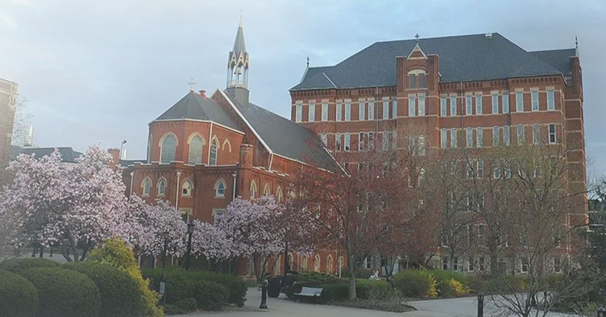 Duquesne University campus exterior in spring with cherry blossoms and historic red brick buildings, representing a Nureva higher education customer deployment.