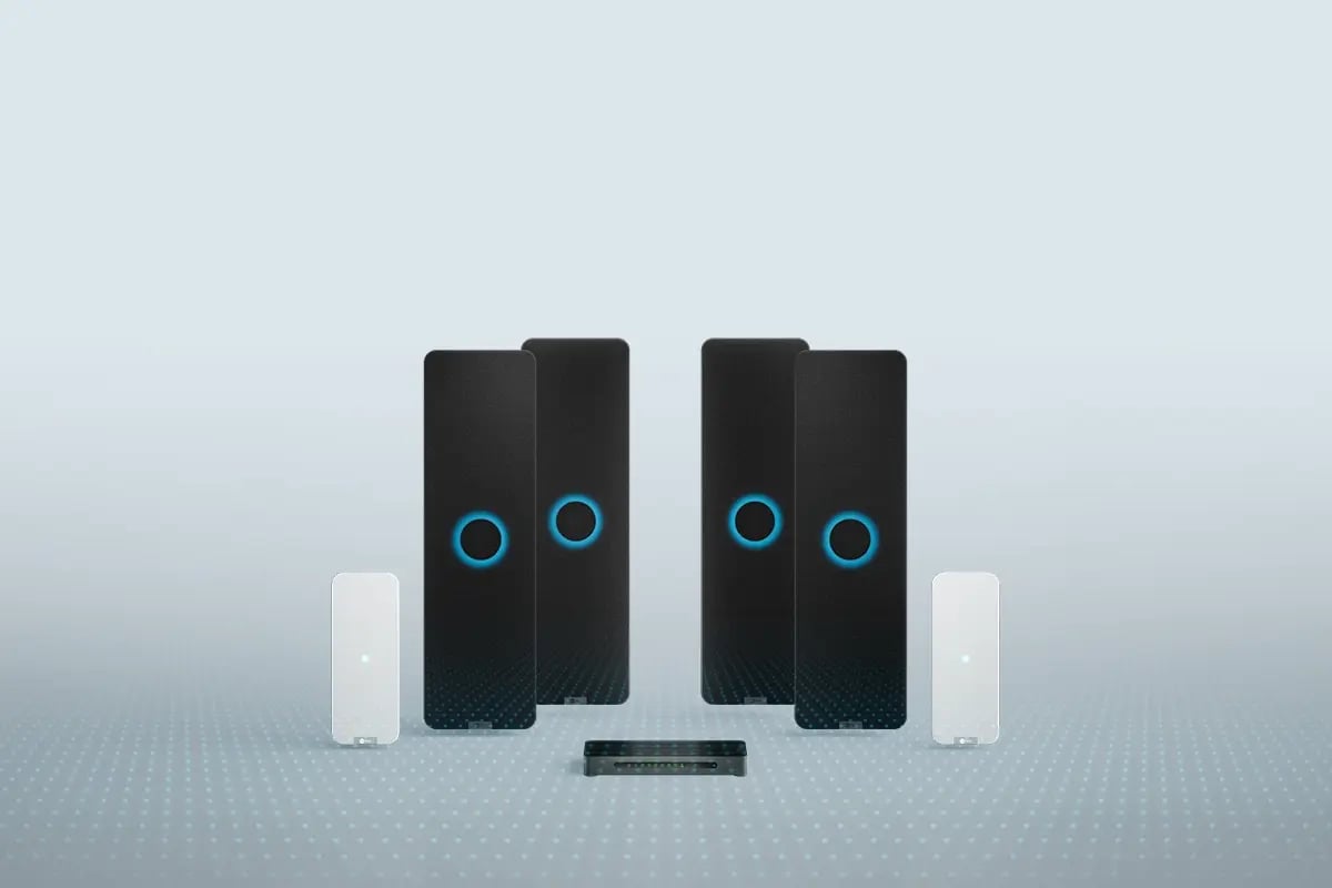 Nureva HDX system with four black audio bars, two white microphone pod and a system hub for large meeting spaces.