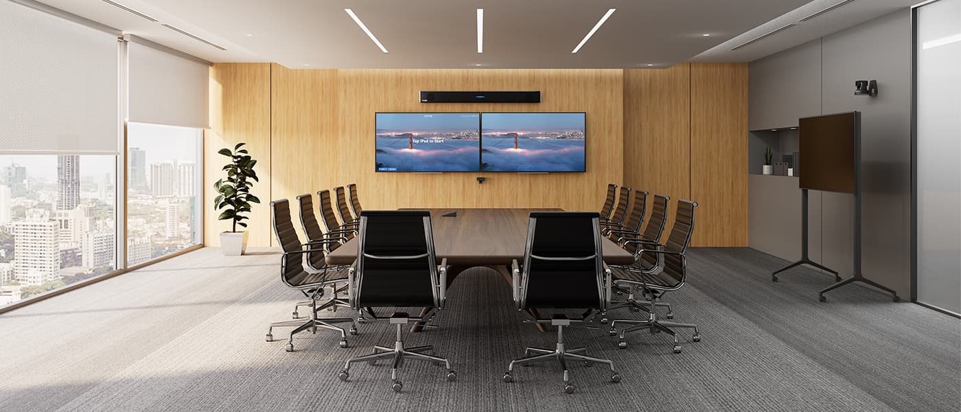 Modern high-rise Zoom Room boardroom featuring a Zoom-certified Nureva HDL310 audio conferencing system mounted above dual wall-displays showing the Zoom Rooms idle screen, with a long dark wood table, black leather executive chairs and floor-to-ceiling windows overlooking a city skyline.