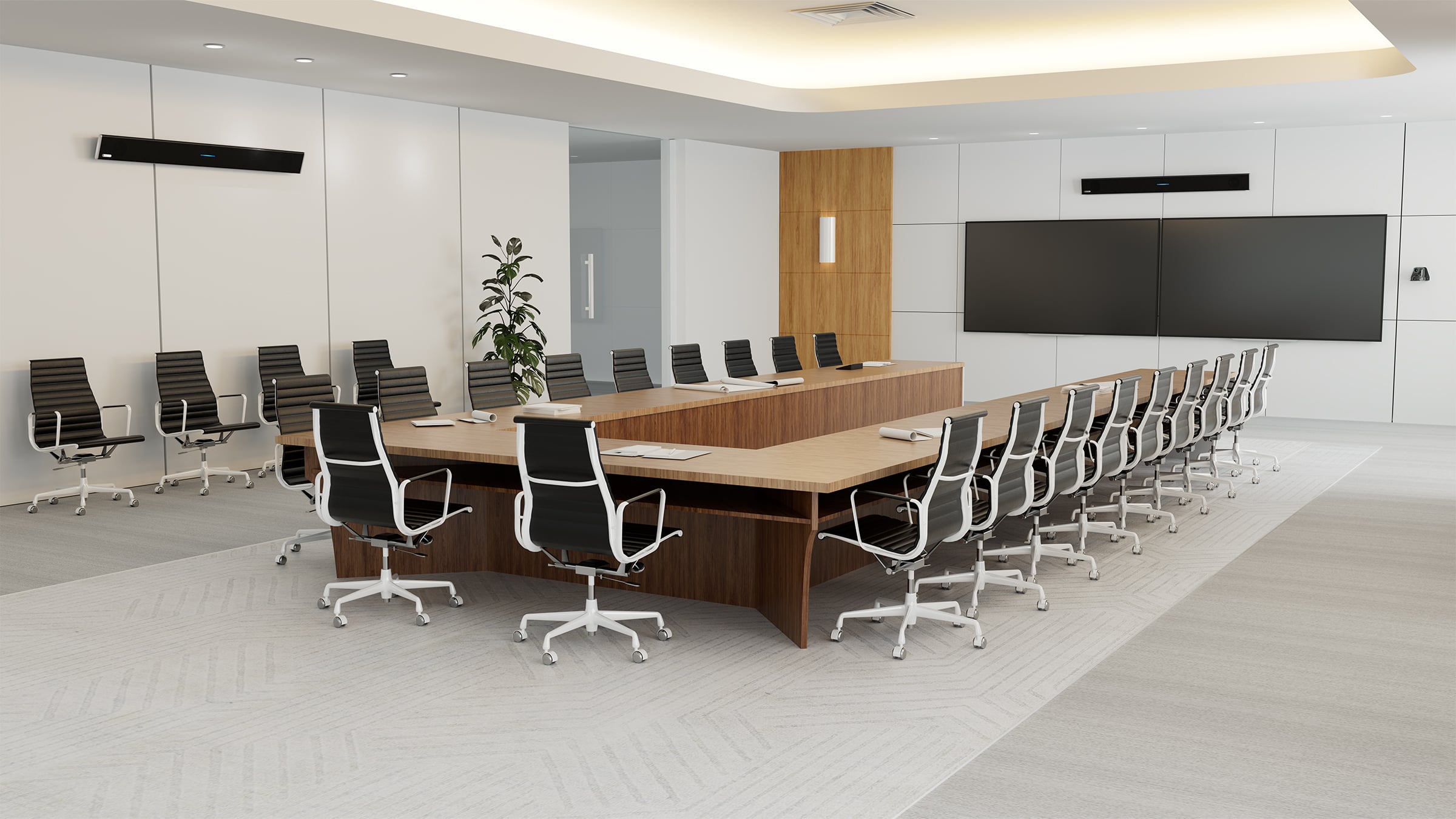 A large conference room with a long rectangular table, black chairs and a Nureva HDL410 audio conferencing system mounted on the walls