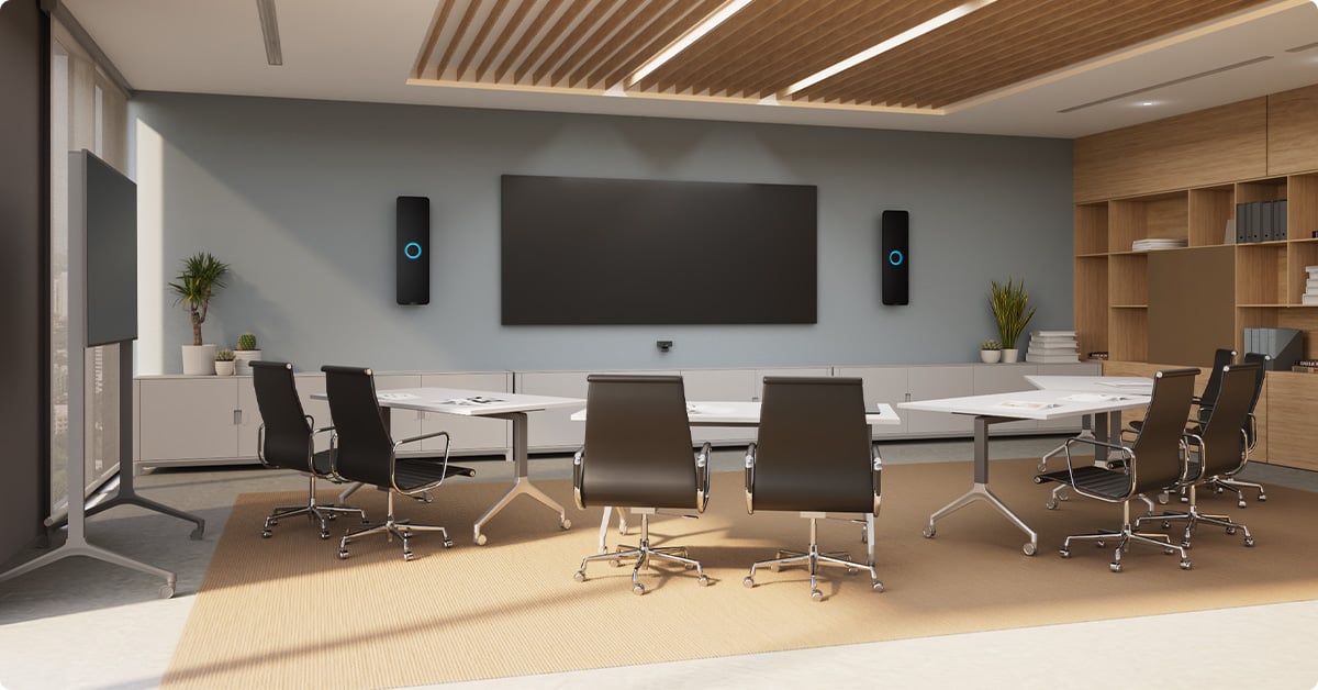 Immersive meeting room with modern conference table, large display, and Nureva HDX 2-bar setup for full-room microphone coverage.