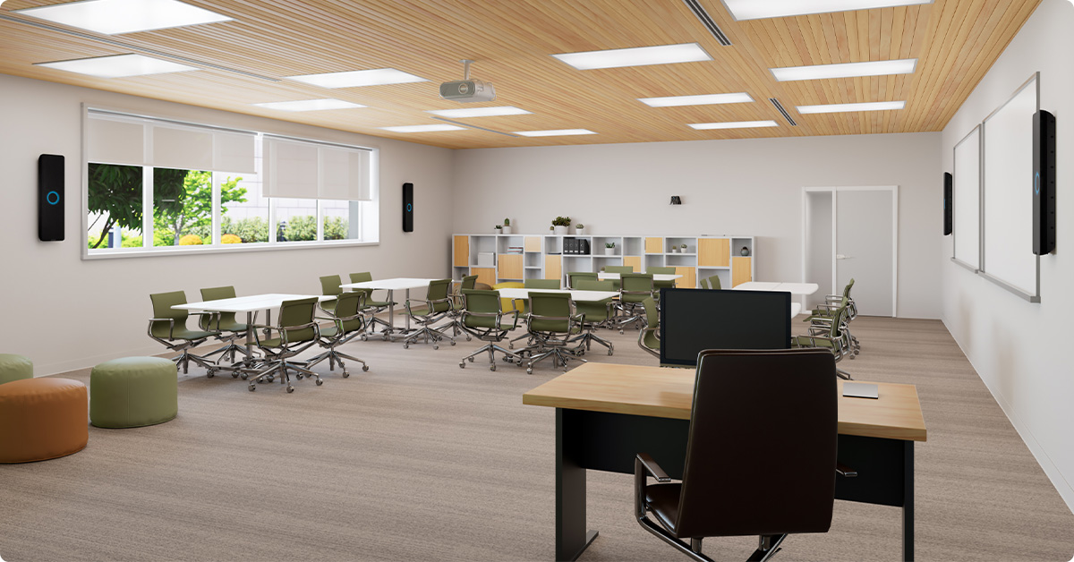 Modern multipurpose classroom with flexible seating, interactive whiteboards, and Nureva HDX in 4-bar setup for full-room mic coverage.