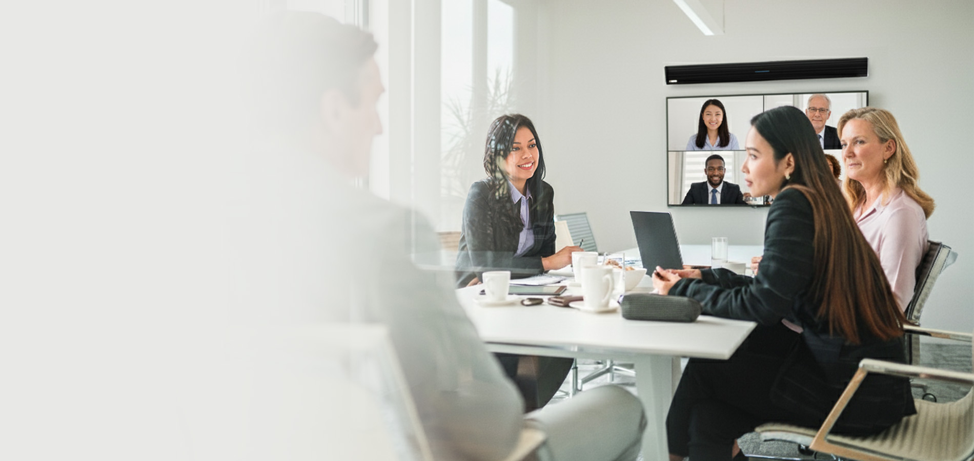 Hybrid meeting setup with Nureva HDL310 audio conferencing system mounted above a display for seamless collaboration between in-room and remote participants.