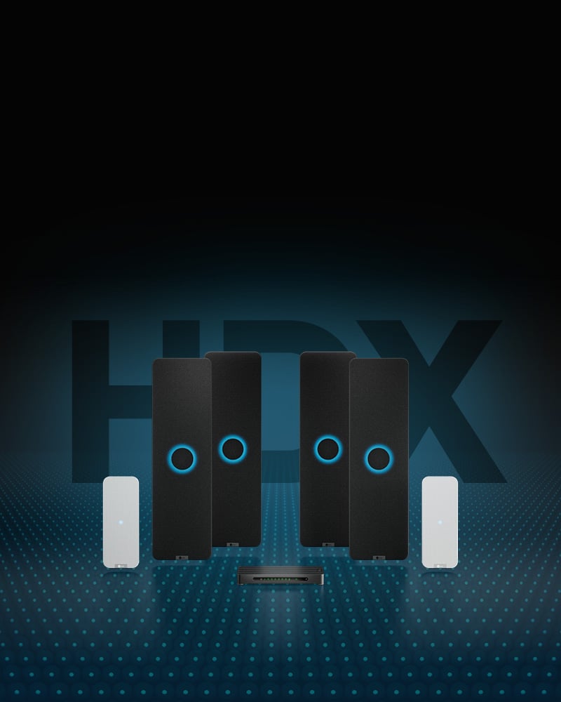 Nureva HDX audio system with four vertical rectangular black audio bars, each with an illuminated blue ring in the middle, two smaller rectangular white microphone pods and the aluminum system hub. An overlay of blue dots represents Microphone Mist technology.