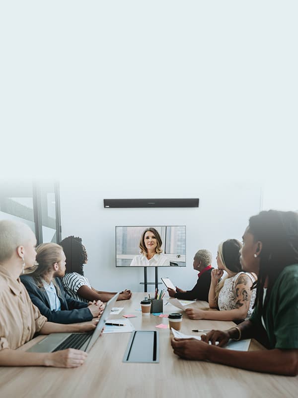 Team in a modern conference room using Nureva audio conferencing system for a video meeting, illustrating ideal solutions for industries like business, education, and government collaboration.