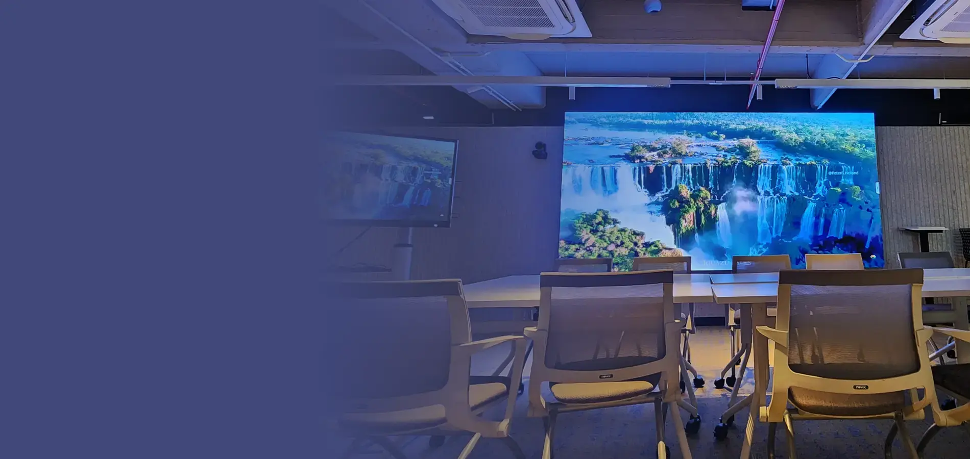 Banco Industrial meeting room with a large LED display wall and Nureva audio system, designed for executive hybrid meetings and corporate collaboration.